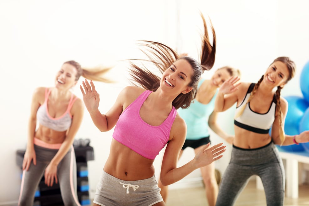 Group of Happy People with Coach Dancing in Gym